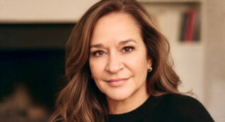A casual headshot of ARA CEO Debi Brannan, a woman with long brown hair wearing a black top.